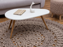 Photo of a beautiful crocheted rug under a coffee table, next to a couch and chair. The photo represents customer success when they get results from the things they buy as part of the customer experience.